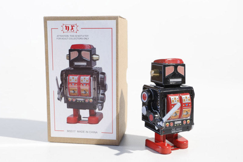 black robot with sword Vintage-style robot tin toy next to its packaging box 