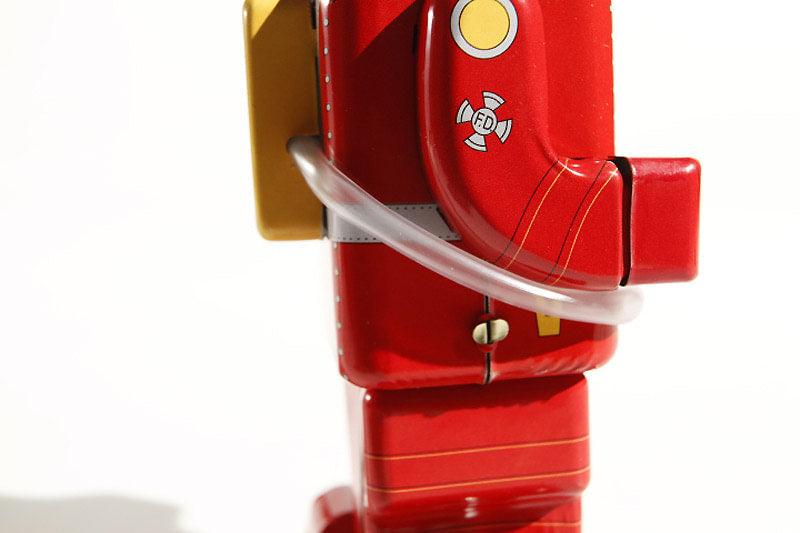 Close-up of a Fireman tin toy with a  hose 