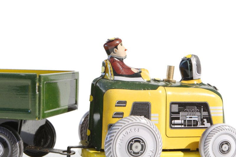 Close up of Mini tractor and trailer tin toy