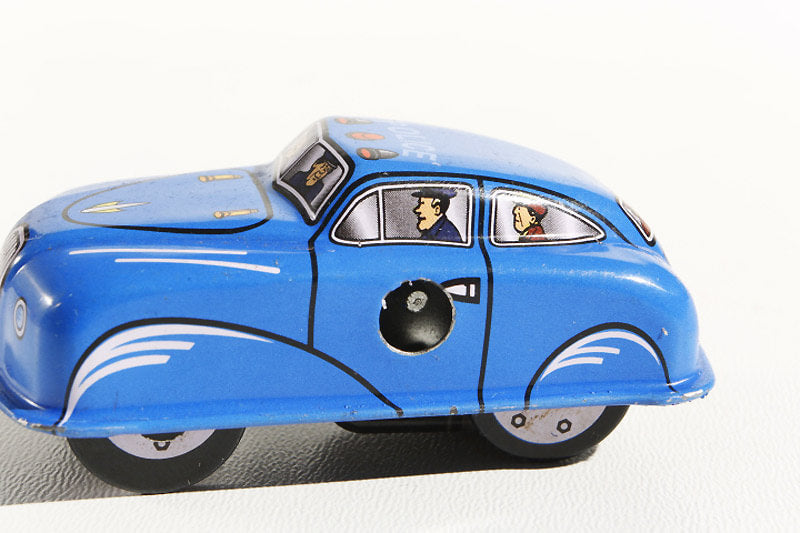 Blue police car tin toy with cartoon characters inside 