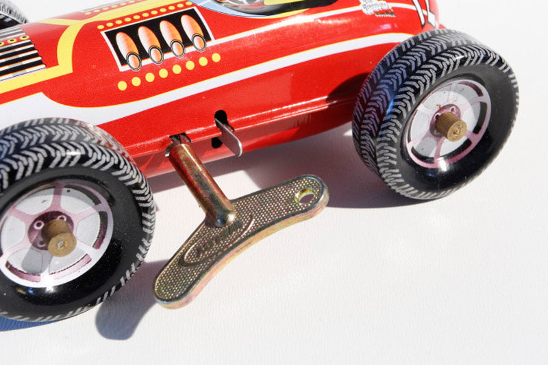 Close up of Red Race Car number 12 tin toy with wind up key
