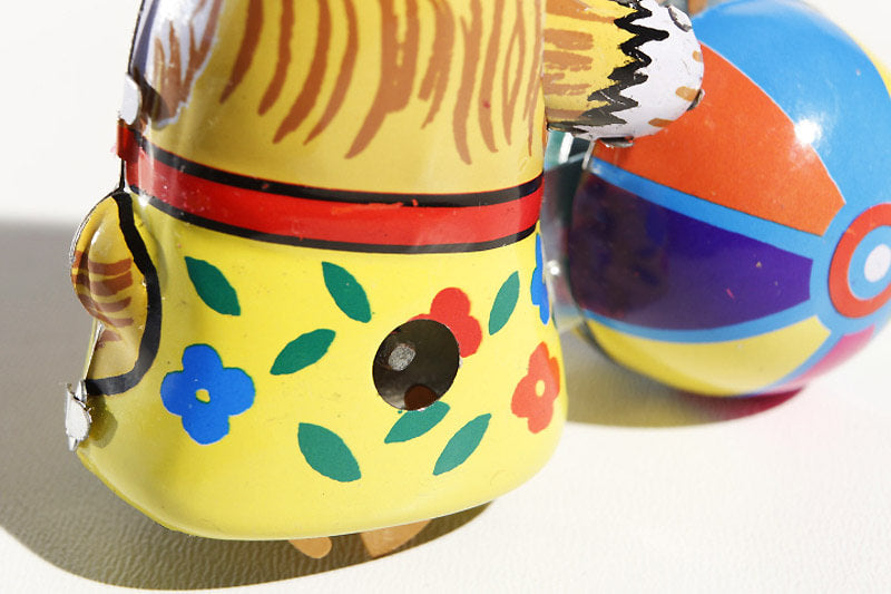 Close up of Small dog with Ball tin toy