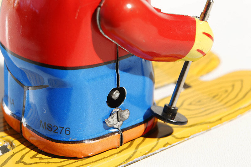 Close up of Small Girl on Ski's tin toy