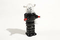 Black robot space trooper tin toy with clear dome and red accents