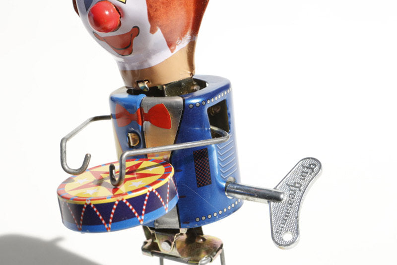 Close up of Welby Drumming Clown tin toy wind up key