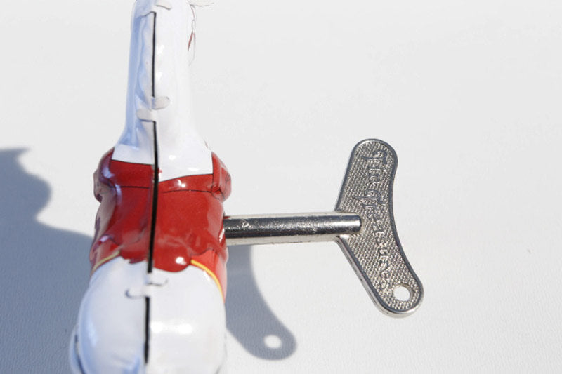 Close up of White Jumping horse tin toy with wind up key